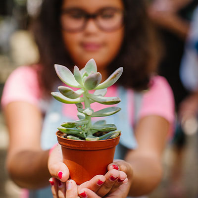 Child Holding a Potted Plant