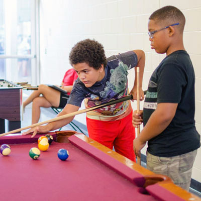 Teens playing pool at the recreation center.